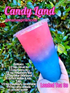 a hand holding up a blue and pink drink in front of some bushes with the words candy land written on it