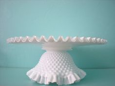 a white cake dish sitting on top of a table