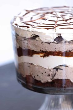 a cake with chocolate and white frosting in a glass dish on a table top