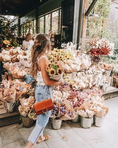 a woman standing in front of a flower shop