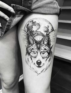 a woman's thigh with a wolf tattoo on it