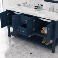 a bathroom vanity with two sinks and marble counter tops