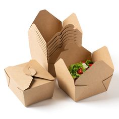 several open boxes with salad in them on a white surface, one opened and the other empty