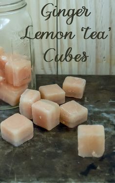 a jar filled with lemon tea cubes on top of a table next to some cut up pieces