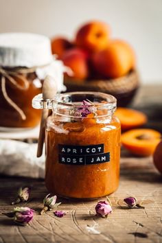 a jar filled with food sitting on top of a wooden table next to oranges