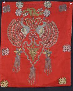 an embroidered red cloth with birds and flowers on it