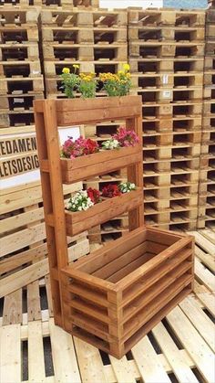 several wooden pallets stacked on top of each other with flower pots in the middle