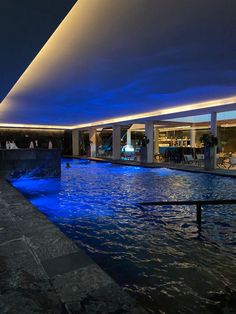 an indoor swimming pool at night with blue lights