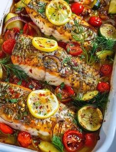 fish with lemons, tomatoes, and other vegetables in a casserole dish