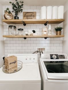 a white washer and dryer sitting next to each other in a room with open shelving