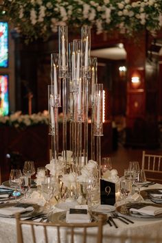 an elegant table setting with tall clear vases