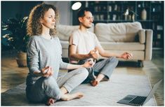 a man and woman sitting on the floor in yoga gear, meditating with each other