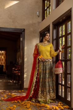 Barang-e-Chaman—a blossoming garden, resplendently captures all the features that make a mehndi the most distinguishably festive mark of a Pakistani wedding. The marigold-colored chiffon kurti is hand-embroidered with sequins and beads, with dabka, kora, and nakshi embroidery on the neckline and sleeves. Paired with a net dupatta with motifs all over in badla embroidery, and finally a raw silk lehenga colored using discharge printing and embroidered using antique-style beads, sequins, dabka, and Wedding Lehenga With Dabka On Jamawar Fabric, Wedding Lehenga In Jamawar With Dabka Detailing, Wedding Anarkali Set With Dabka Work In Multicolor, Multicolor Anarkali Set With Dabka Work For Wedding, Wedding Multicolor Anarkali Set With Dabka Work, Traditional Wedding Wear With Dabka On Jamawar, Bollywood Style Sets With Naqshi For Traditional Ceremonies, Multicolor Naqshi Anarkali Traditional Wear, Naqshi Anarkali Set For Traditional Ceremonies And Festivals