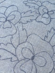 a close up view of the fabric with flowers and hearts drawn on it's side