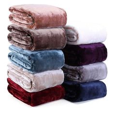 towels stacked on top of each other in various colors and sizes, all folded up