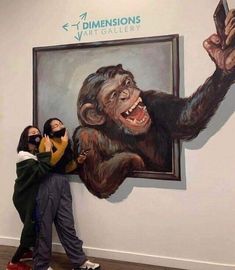 two people standing next to each other in front of a painting with a monkey on it