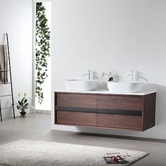 two white sinks sitting on top of a wooden cabinet