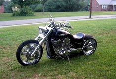 a black motorcycle parked on top of a lush green field