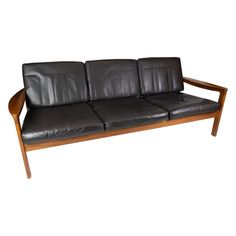 a black leather couch sitting on top of a wooden frame