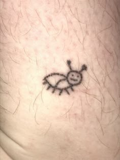 a small tattoo on the side of a person's leg that has an insect drawn on it