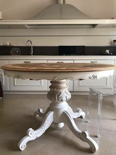 a white table with a wooden top in a kitchen next to a stove and oven