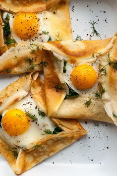 some food is laying on a plate with eggs and herbs in it, as well as two slices of pita bread