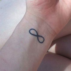 a woman's wrist tattoo with an infinite symbol on it, in black ink