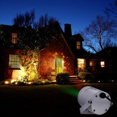 a house with christmas lights on it and a camera in the front yard at night