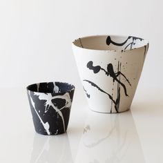 two black and white cups sitting next to each other