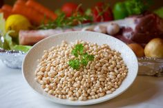 a white plate topped with beans next to vegetables