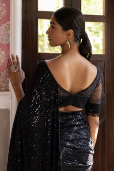 Beautiful black sequin embroidered saree. It comes with a sequined work all over, a bootcut neck, and a sleeveless sequined blouse. It is best suited for night parties & weddings. Shop designer saris online in the USA from Pure Elegance Disclaimer: The actual product may vary slightly from the image. These are custom orders, hence expect slight variation in color, placement of the motif or buta. ESTIMATED DELIVERYBecause this is a custom order, it would take about 4 weeks from the date of purcha Sequined Blouse, Night Parties, Boat Neck Blouse, Embroidered Saree, Black Saree, Jumpsuit Online, Blouse For Women, Saree With Blouse, Blouse Online