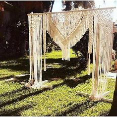 an outdoor wedding ceremony setup with macrame and white crocheted fabric draped over it