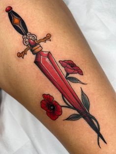 a tattoo with a dagger and flowers on it