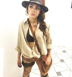 a woman dressed up as indiana jones posing for the camera with her hat and boots on