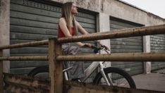 a woman riding a bike next to a building