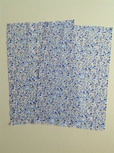 two pieces of blue and white paper with small flowers on them are folded in half