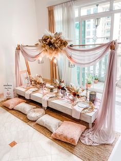 a table set up for a party with pink and gold decorations on top of it