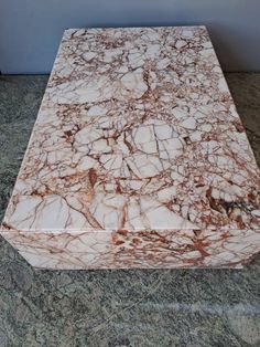 a marble table top with brown and white veining on the edges, sitting on a granite floor