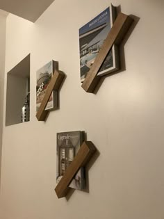 three wooden shelves on the wall with magazines