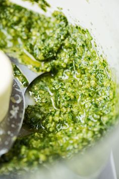 a food processor filled with green pesto