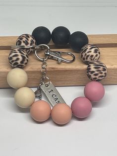 an assortment of different colored beads on a keychain with a name tag attached to it