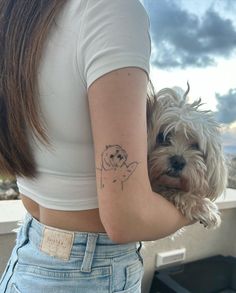 a woman with a small dog tattoo on her left arm and right arm behind her back