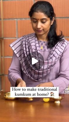 a woman is sitting at a table with some gold objects in front of her and the words how to make traditional kumkum at home?