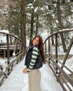 a woman standing on a bridge in the snow