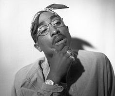 a black and white photo of a woman with glasses on her head looking up at the sky