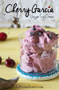 a bowl filled with ice cream next to cherries on a yellow tablecloth and text overlay reads cherry grancia vegan ice cream