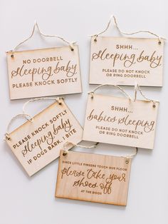 four wooden signs hanging from string with sayings attached to the strings, on a white background