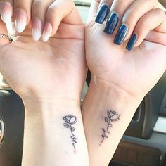 two women with matching tattoos on their arms holding each other's hands in the car