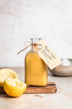 a glass jar filled with liquid next to sliced lemons