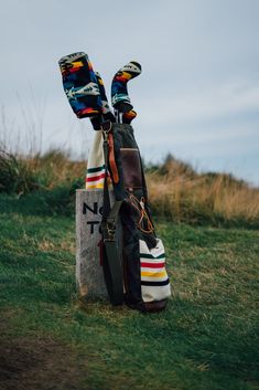 two pairs of shoes are sitting on top of a rock in the grass near a sign